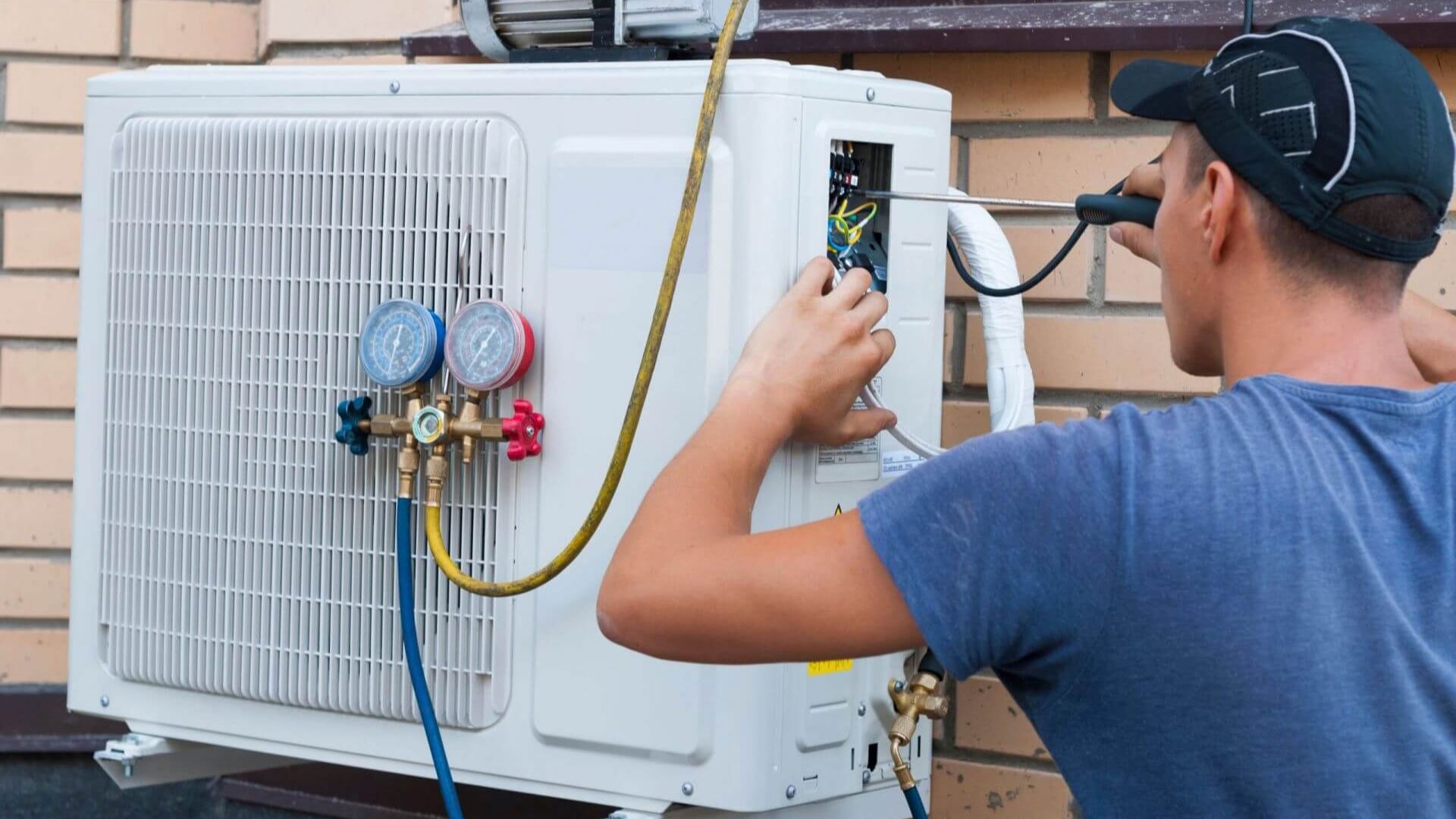 Outdoor central air conditioner condenser beside a house
